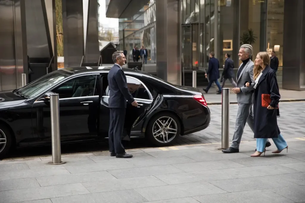 Chauffeur Jet Transfert Service devant une berline noire